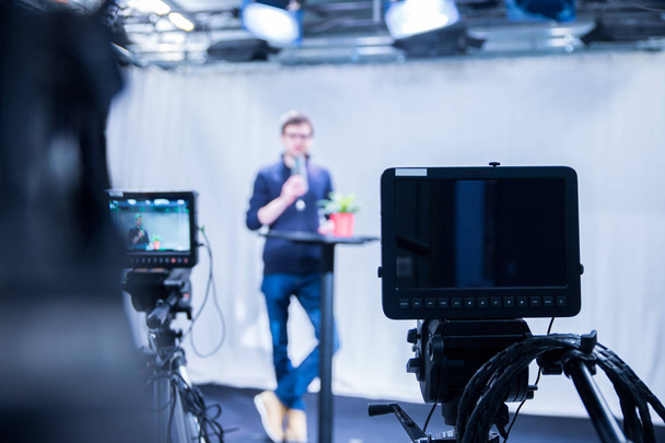 Muž novinář v televizním studiu mluví do mikrofonu, filmové kamery - Fotografie, Obrázek