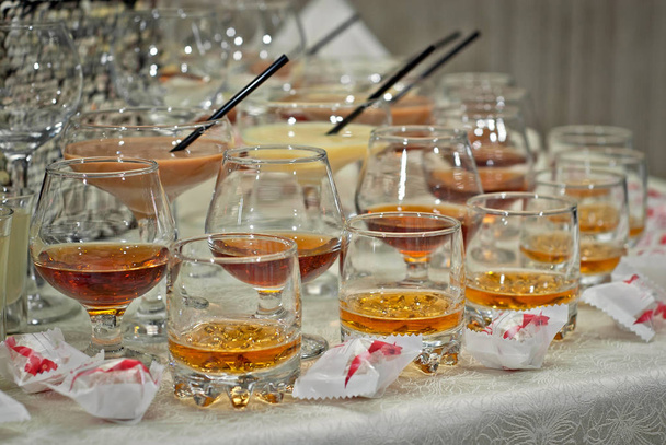 Lasi lasit värillisiä juomia pöydälle. alkoholijuomat buffetissa
 - Valokuva, kuva