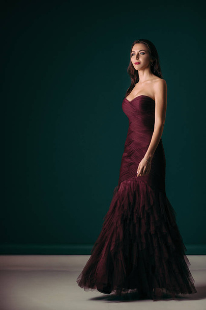 woman in evening dress posing over dark background - Photo, image
