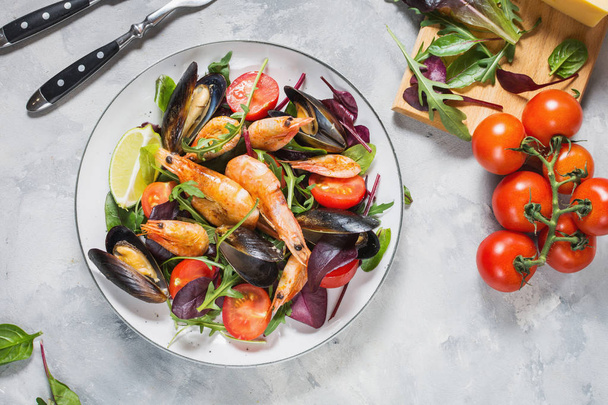 Fresh seafood salad, mussels, shrimp, fresh vegetables and herbs. Top view - Photo, Image