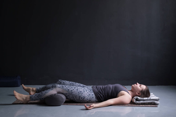mulher trabalhando fora, fazendo exercício de ioga no chão de madeira, deitado em Shavasana
 - Foto, Imagem