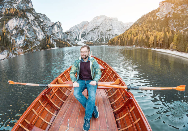uomo in barca galleggiante e canottaggio sul Lago Pragser Wildsee, o Lago Di Braies nelle Dolomiti italiane
 - Foto, immagini