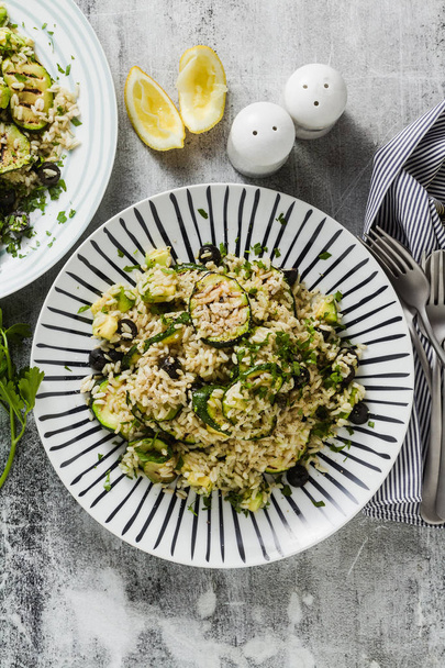 salad with rice with zucchini, avocado, olives and capers. healthy spring summer vegan cuisine recipe for the whole family or party - Fotografie, Obrázek