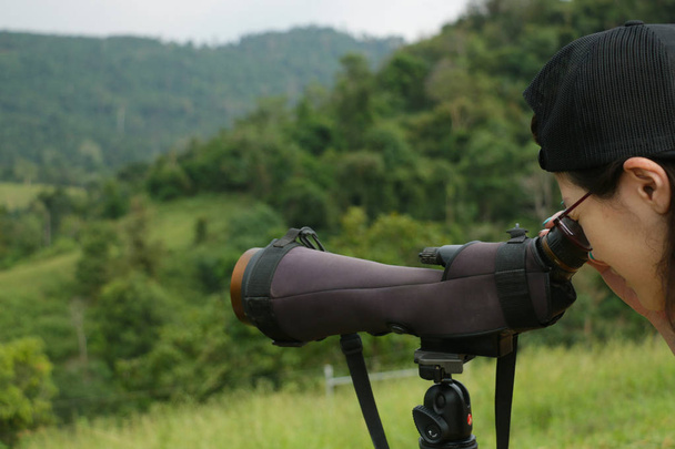 Detail žena použít dalekohled na horu pro línání zvířat v zeleném lese; měkké zaostření. - Fotografie, Obrázek
