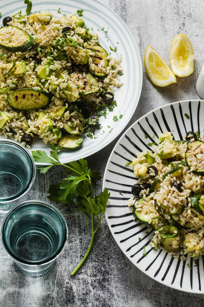 salad with rice with zucchini, avocado, olives and capers. healthy spring summer vegan cuisine recipe for the whole family or party - Fotografie, Obrázek