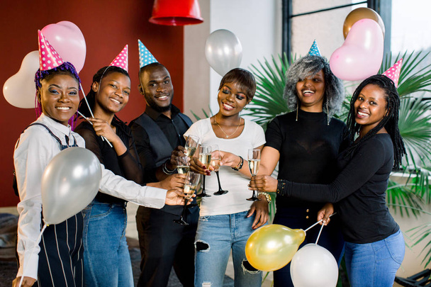 Group of happy African friends drinking champagne and celebrating Birthday party - Photo, image
