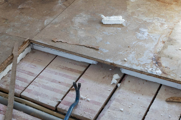 Polystyrol-Holzplatten mit Werkzeug vom Fußboden entfernen - Foto, Bild