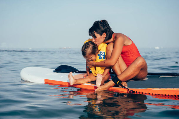 Moeder met dochter op een paddle board - Foto, afbeelding