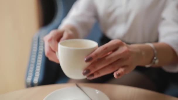 Woman drinks tea cup in cafe - Materiał filmowy, wideo