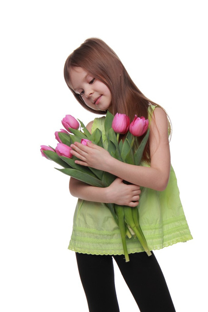 Happy little girl with a big bouquet of tulips - 写真・画像