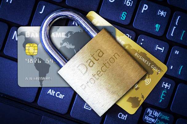 Golden padlock on top of credit or debit cards on computer keyboard. Concept of Internet security, data privacy, cybercrime prevention for online shopping transaction payments. - Photo, Image
