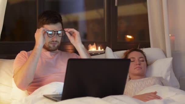man in bed closing laptop and turning light off - Video, Çekim