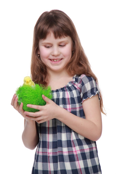 Beautiful girl holding a green basket with a little chicken for Easter - Zdjęcie, obraz