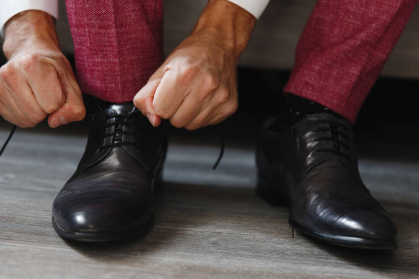 El hombre atando los cordones de los zapatos
 - Foto, imagen