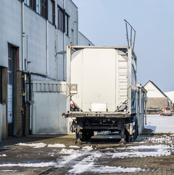 parked tank trailer at the door of a warehouse, outdoor exterior of a workplace - Photo, Image