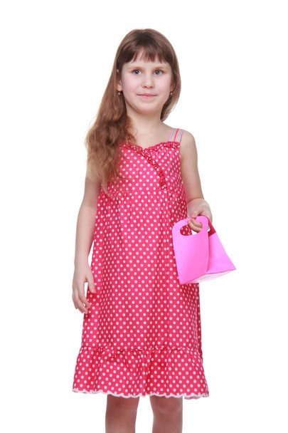 Healthy little girl in a summer dress holding a gift - Foto, afbeelding