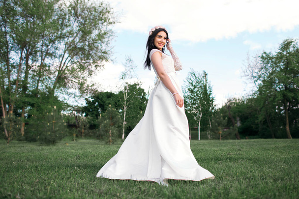 schöne Braut posiert im Park, glückliche Brünette. - Foto, Bild