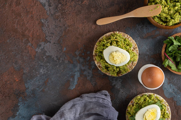 Crispy rice cakes with avocado puree and boiled eggs - Fotoğraf, Görsel