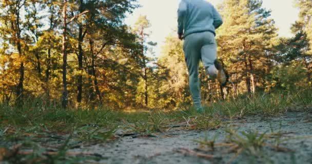 Az ember fut át az őszi táj közelről. - Felvétel, videó