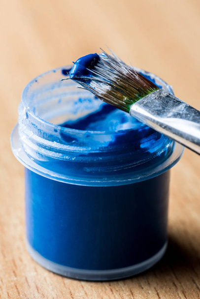 small jar of blue gouache paint with tassel. Vertical frame - Photo, Image