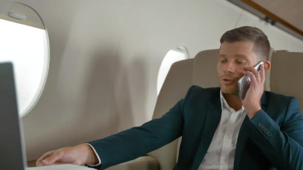 rijpe zakenman praten via de mobiele telefoon in vliegtuig - Video