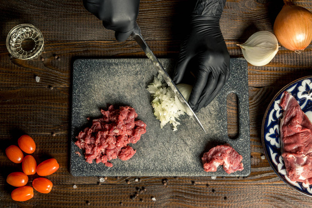 les mains féminines coupent les oignons, la viande est proche. Cadre horizontal
 - Photo, image