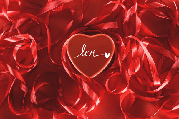 close-up view of beautiful red heart with "love" lettering and decorative ribbons, valentines day background - Photo, Image