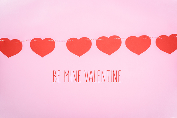 beaux cœurs rouges décoratifs suspendus à la corde sur fond rose avec lettrage "be mine valentine"
  - Photo, image