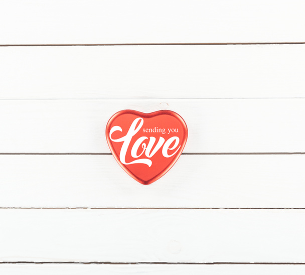 top view of red heart shaped box with "sending you Love" lettering on white wooden background, st valentines day concept  - Photo, Image