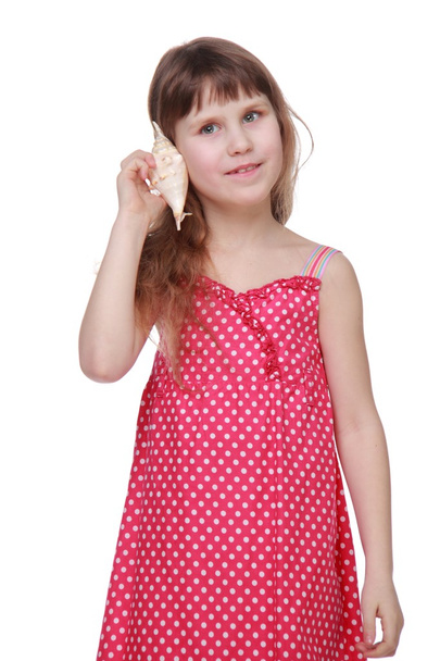 Cute little girl in a light dress holding a seashell - Fotó, kép