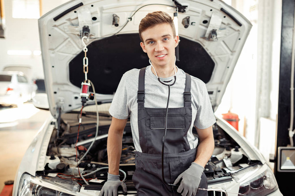 A young man is at work at a car service - Foto, Imagen