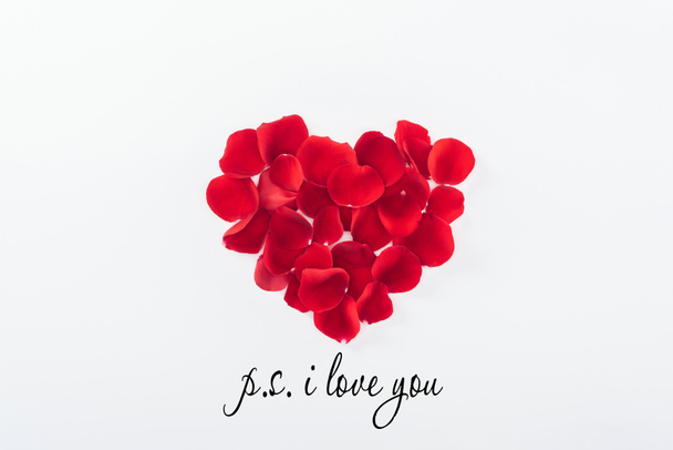 top view of heart made of red rose petals isolated on white, st valentines day concept with "p.s. I love you" lettering - Foto, Bild