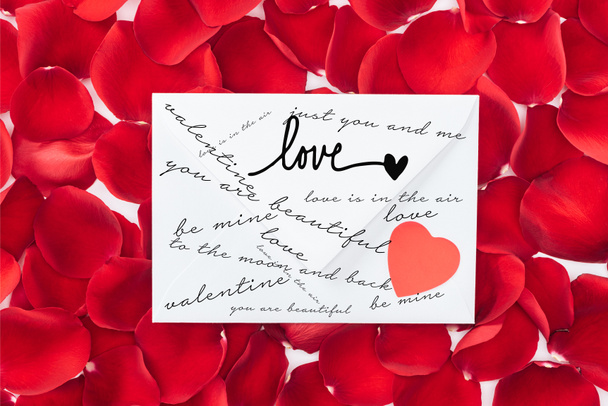 Widok z góry koperty z miłości, serca i czerwone płatki róż na tle, st Walentynki koncepcja - Zdjęcie, obraz