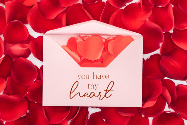 top view of envelope with "you have my heart" lettering, heart shaped confetti and red rose petals on background, st valentines day concept - Фото, изображение