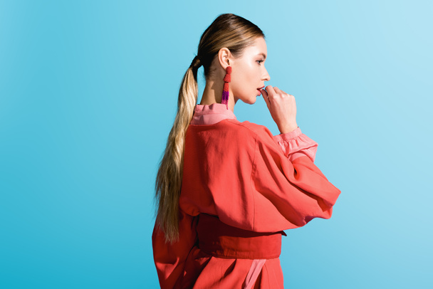beautiful stylish girl posing in trendy living coral clothing isolated on blue - Foto, afbeelding
