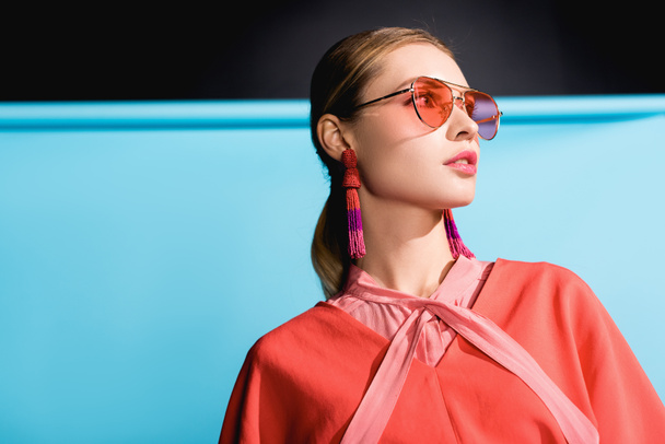 mujer de moda posando en ropa de coral vivo y gafas de sol en azul
 - Foto, imagen