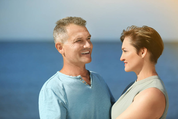 Happy mature couple at beach on sunny day - Foto, Imagen