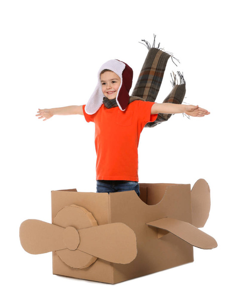 Cute little boy playing with cardboard airplane on white background - Foto, Bild