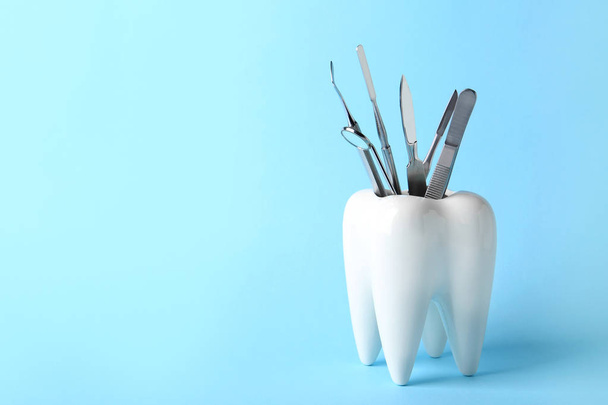 Tooth shaped holder with professional tools on color background. Space for text - Fotó, kép