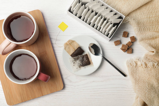 Flat lay composition with fresh tea and bags on wooden background - Φωτογραφία, εικόνα