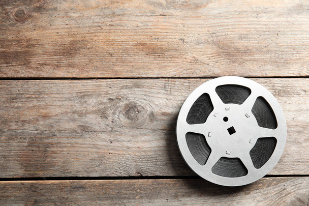 Movie reel on wooden background, top view with space for text. Cinema production - Foto, immagini