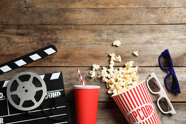 Flat lay composition with clapper, popcorn and space for text on wooden background. Cinema snack - Fotoğraf, Görsel