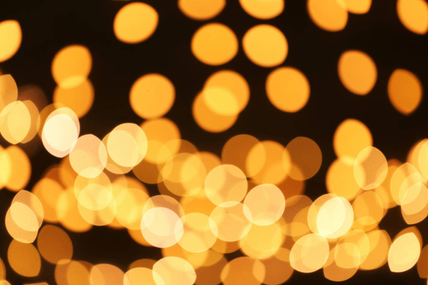 Beautiful golden lights on dark background. Bokeh effect - Fotografie, Obrázek