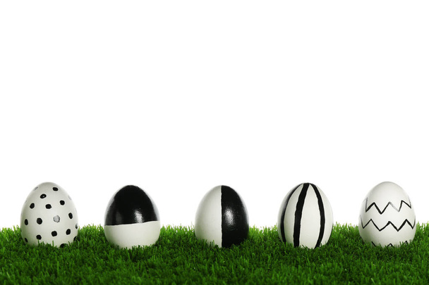 Line of painted Easter eggs on green lawn against white background - Foto, Imagem