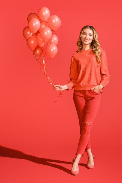 cheerful fashionable girl posing with living coral balloons. Pantone color of the year 2019 concept - Valokuva, kuva