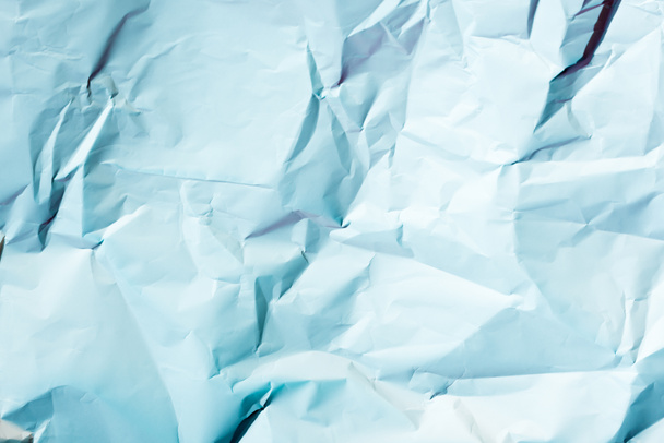 bovenaanzicht van lichte blauwe verfrommeld papier textuur - Foto, afbeelding