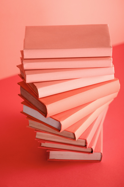 pile of books on living coral background. Pantone color of the year 2019 concept - Foto, Imagem