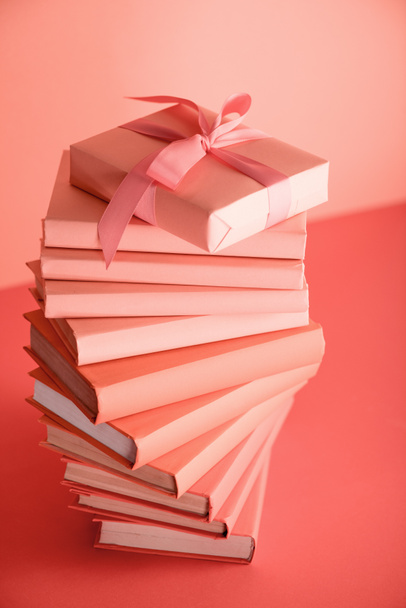 Kitaplar ve yaşayan bir hediye yığını Mercan rengi. Yıl 2019 kavramının Pantone renk - Fotoğraf, Görsel