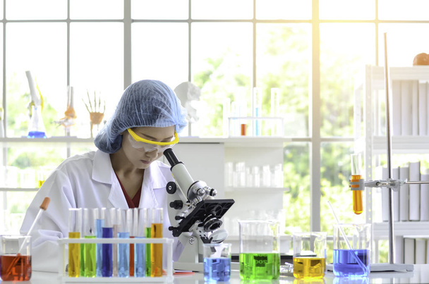 Женщина-ученый проводит эксперимент под микроскопом в лаборатории. Фотоконцепция медицинских технологий и фармацевтических исследований и разработок
. - Фото, изображение