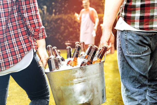 cropped shot of people carrying bucket full of beer bottles and ice - Foto, Imagem
